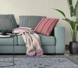 Living room with a teal sofa, patterned cushions, and a plant.