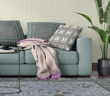 Living room with a teal sofa, patterned cushions, and a plant.