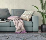 Living room with a teal sofa, patterned cushions, and a plant.