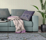 Living room with a teal sofa, patterned cushions, and a plant.