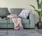 Living room with a teal sofa, patterned cushions, and a plant.