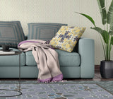 Living room with a teal sofa, floral pillow, and patterned rug.
