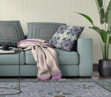Living room with a teal sofa, patterned cushions, and a plant.