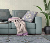Living room with a teal sofa, floral pillow, and patterned rug.
