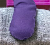 Ultimate Hot & Cold Herbal Neck Pillows - Natural Pain Relief on a gray surface with a pink object in the background