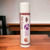 Lip balm stick with 'Hot Cocoa' flavor on a wooden surface