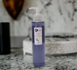 Purple bottle of lavender soap on a marble surface with a blurred background