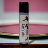 Lavender lip balm with a purple label on a wooden surface