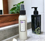 Two bottles of men's grooming products on a bathroom counter with a plant in the background.