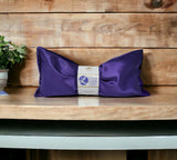 Ultimate Hot & Cold Herbal Neck Pillows - Natural Pain Relief with a label on a wooden surface