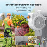 Retractable Garden Hose Reel-1/2 in-65ft with a person using it in a garden setting.