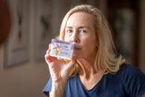 Woman holding a soap bar with a label in front of her face