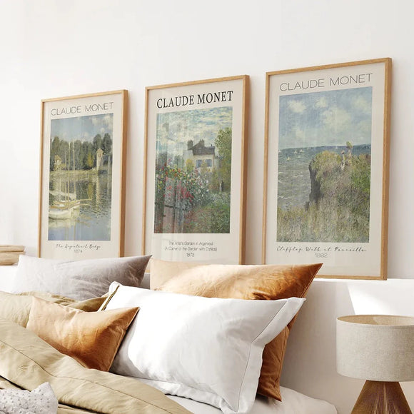 Three framed artworks of Claude Monet on a wall above a bed with pillows. Monet Set of 3 Printable Exhibition Posters