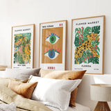 Modern Abstract Flower Market Set of 3 Piece on a wall above a sofa with pillows.