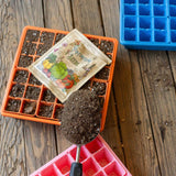 Seedling tray with soil, seed packet, and trowel on a wooden surface