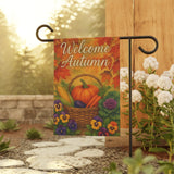 Decorative garden flag with 'Welcome Autumn' text and fall elements on a stand outdoors.