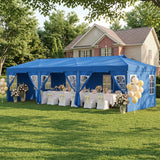 A large blue event marquee tent set up on a green lawn in front of a house, with white tablecloths, chairs, floral arrangements, and yellow balloons around it.