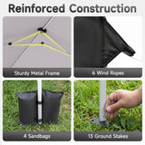 A four-panel feature graphic titled 'Reinforced Construction' showing details of a black tent or canopy frame: the inner canopy structure with yellow tension lines, a close-up of black fabric and rope, two black sandbags holding a silver pole on grass, and a hand inserting a ground stake into a metal base. Text labels mention sturdy metal frame, 6 wind ropes, 4 sandbags, and 13 ground stakes.