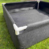 Gray Fabric Raised Worm Farm with white pipes on a grassy background