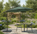 Outdoor patio set with green umbrella, table, and chairs in a garden setting.