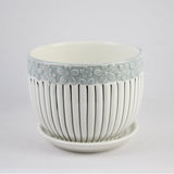 Ceramic flower pot with floral pattern and striped design on a white background