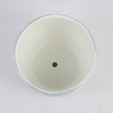 White ceramic pot with a central hole on a white background