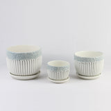 Three ceramic cups with decorative patterns on a light gray background