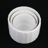 Set of three white ceramic bowls stacked on a black background 3-Piece White Stoneware Planter Set with Fluted Design