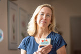 Woman holding a bar of soap with a floral design in a room setting
