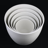 Set of white ceramic bowls of different sizes on a black background 5-Piece White Plastic Planter Pot Set – Modern Round Design