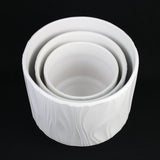 Set of white ceramic bowls stacked on a black background 3-Piece White Stoneware Planter Pot Set with Embossed Texture