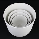 4-Piece White Plastic Round Planter Pot Set – Minimalist Modern Design of different sizes on a black background
