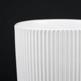 Close-up of a 3-Piece White Stoneware Planter Pot Set with Ribbed Texture with ribbed texture on a black background