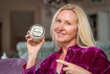Woman holding a container of ALMOND ARNICA SALVE 8 oz. ~ ALMOND MILK