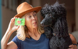 Woman holding aCRISP APPLE SOAP SLICE 5.5 oz. with a red apple next to a black poodle.