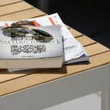 Stack of books on a wooden table with sunglasses on top