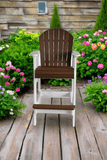 Bar chair on a wooden deck with flowers and plants in the background