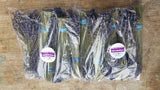 Bundles of lavender in clear plastic packaging on a wooden surface