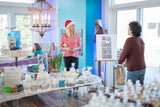 Woman in a store with various products on display, including candles and soaps.