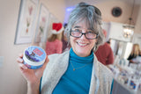 Woman holding a container of CROTCH GREASE 8 oz. ~ UNSCENTED