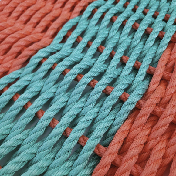 Close-up of turquoise and orange ropes intertwined.