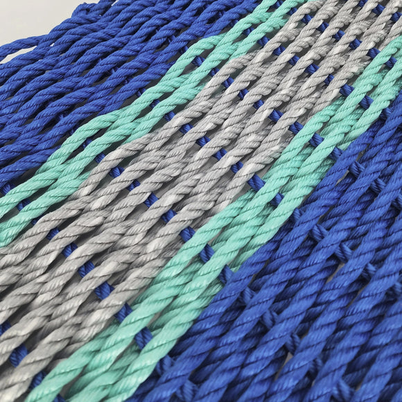 Close-up of blue, gray, and green braided ropes on a light background