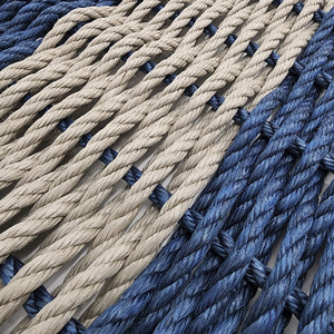 Close-up of blue and beige ropes with black knots.