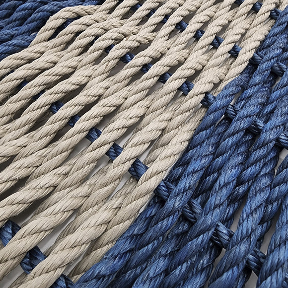 Close-up of blue and beige ropes with black knots.