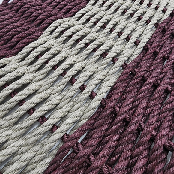 Close-up of braided ropes in purple and beige on a white background
