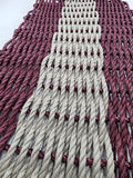 Close-up of woven pattern with alternating red and white ropes.