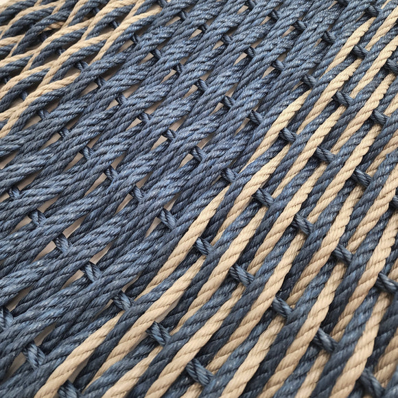 Close-up of a woven mat with blue and beige ropes.