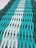 Close-up of teal and white ropes arranged in a pattern.