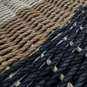 Close-up of woven rope mats in beige, brown, and navy.