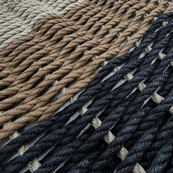Close-up of woven rope mats in beige, brown, and navy.